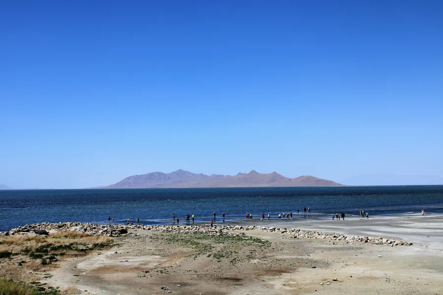 The shoreline of the Great Salt Lake, pale mineral flats running out to open water and distant ranges.