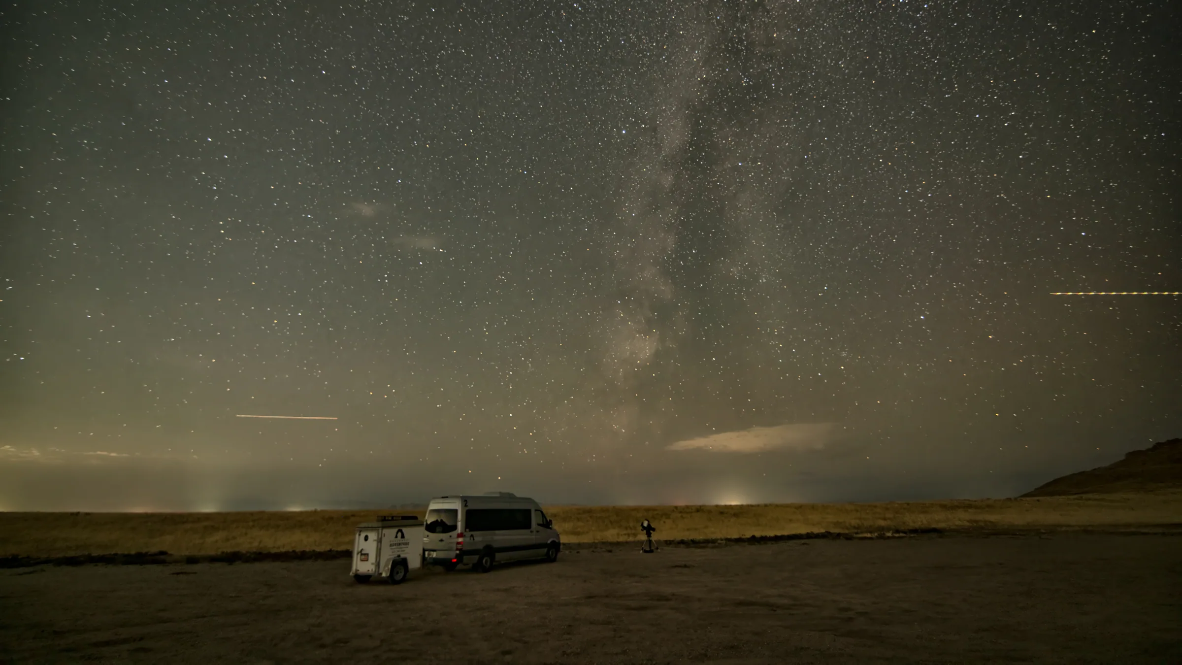 The Milky Way over Antelope Island with the tour van parked on the open shoreline