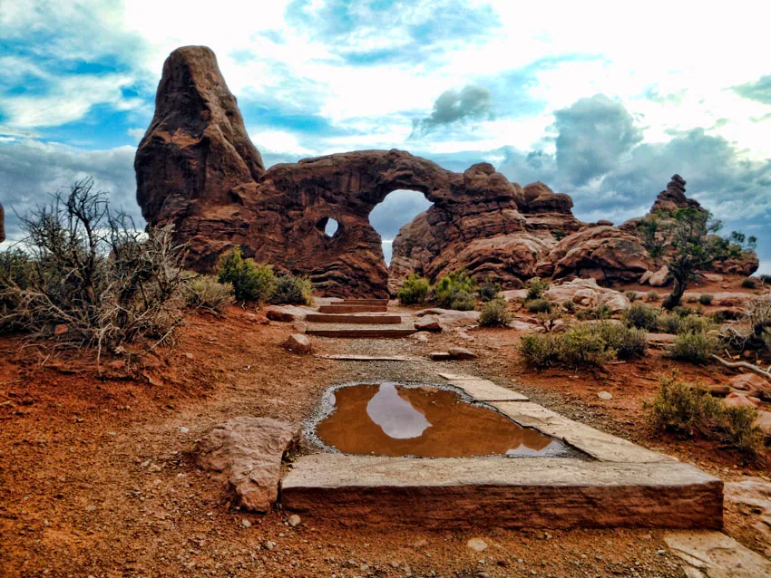 Turret Arch above a rainwater pool held in the sandstone below it, Arches National Park