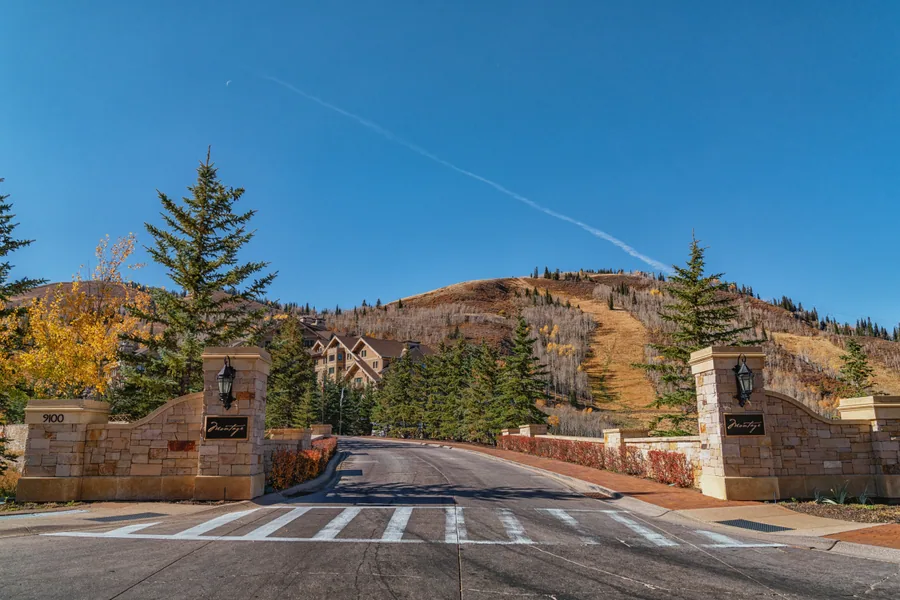 The approach road into Deer Valley Resort, stone gateposts and a marked crossing where the resort road leaves the highway.
