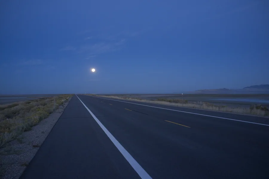 The road across Antelope Island under a moonlit sky, long after the last of the daylight has gone.