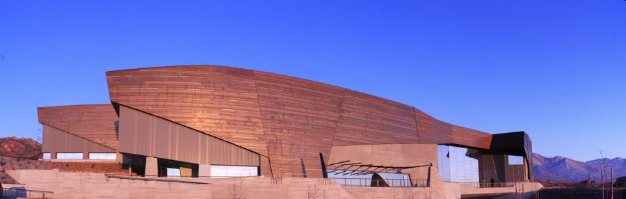 The weathered copper skin of the Natural History Museum of Utah, banded like the rock strata it was modeled on.