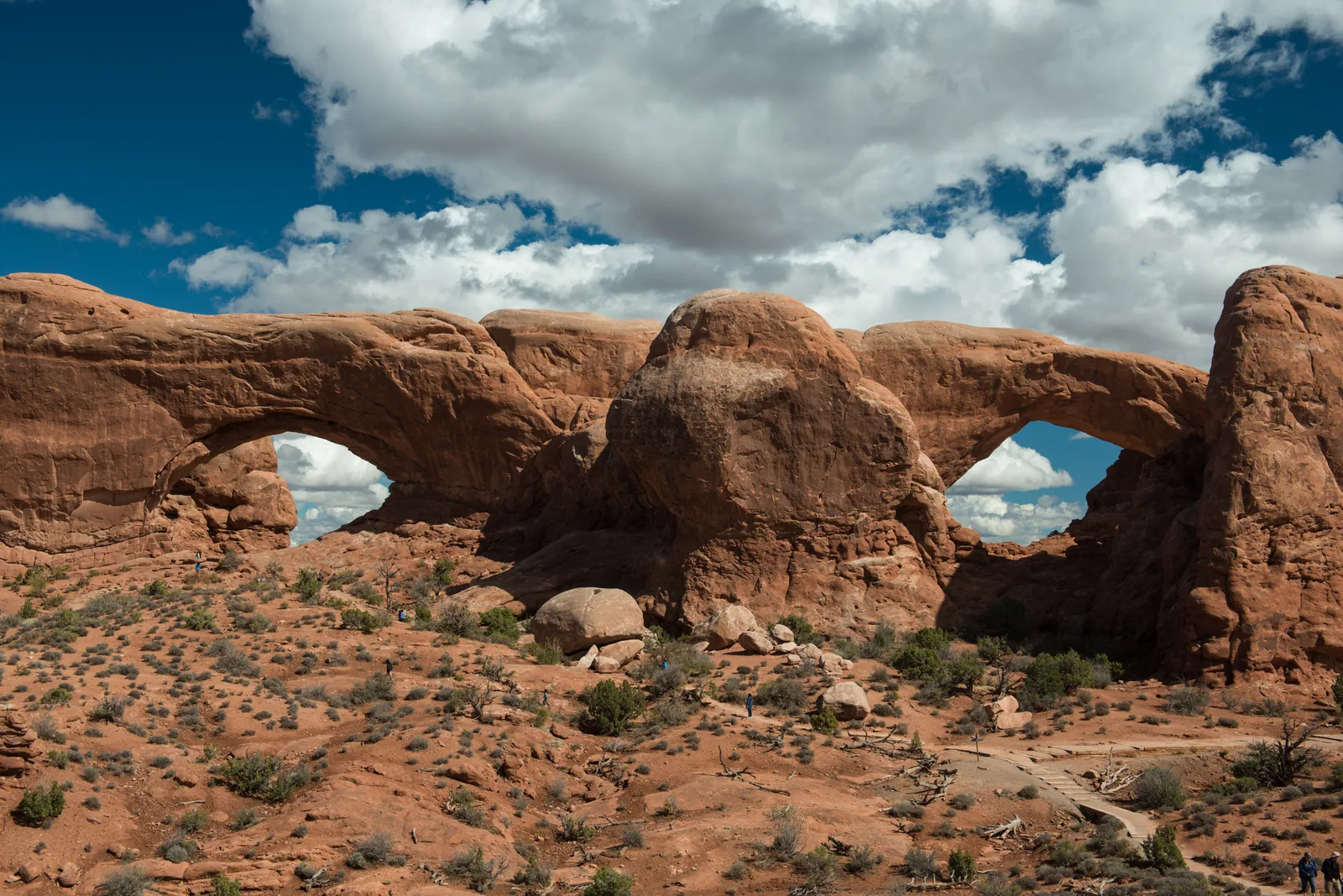 North Window and South Window side by side in the Windows Section of Arches National Park, two large openings in a single sandstone wall.