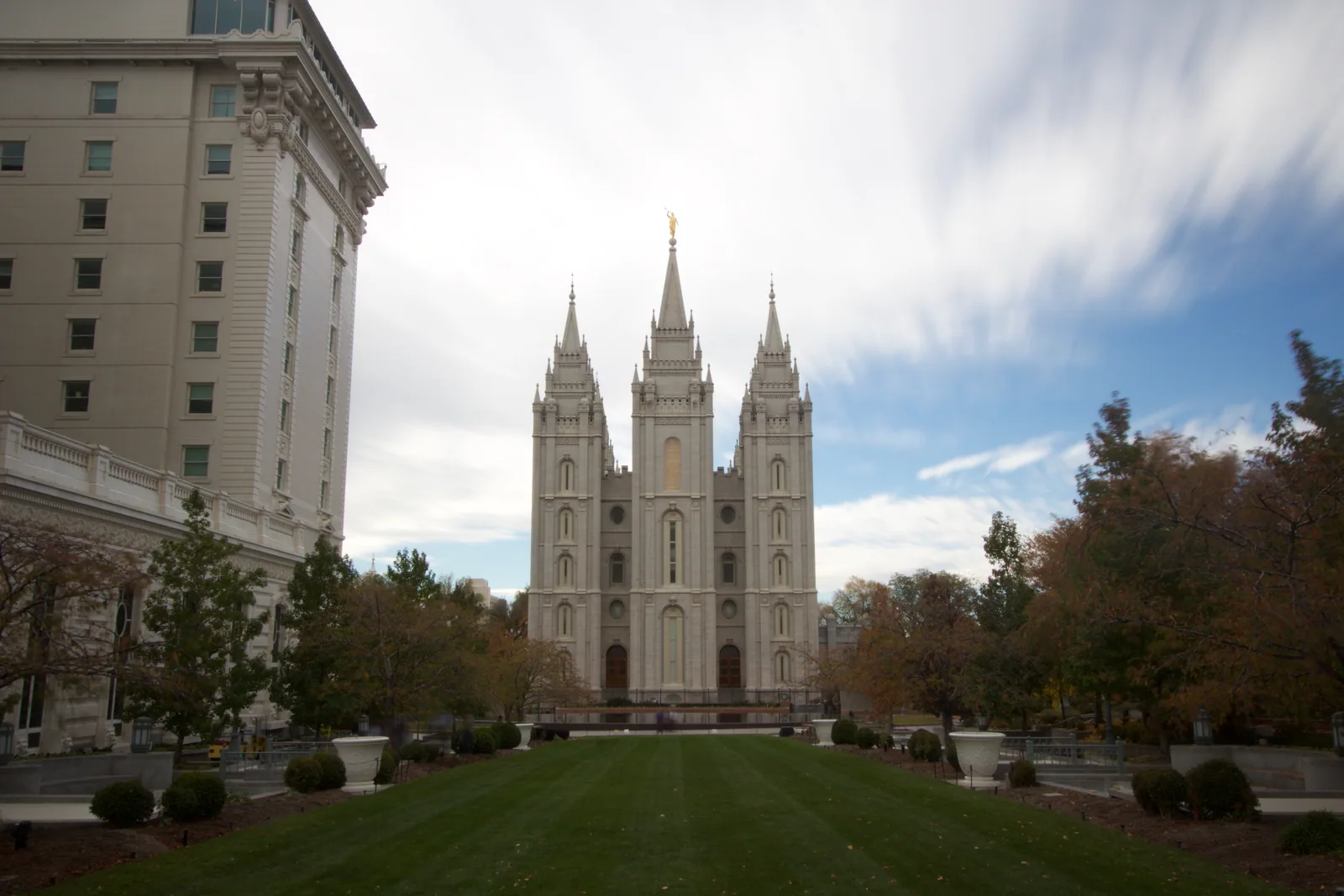 The six granite spires of the Salt Lake Temple rising above the trees and lawns of Temple Square.
