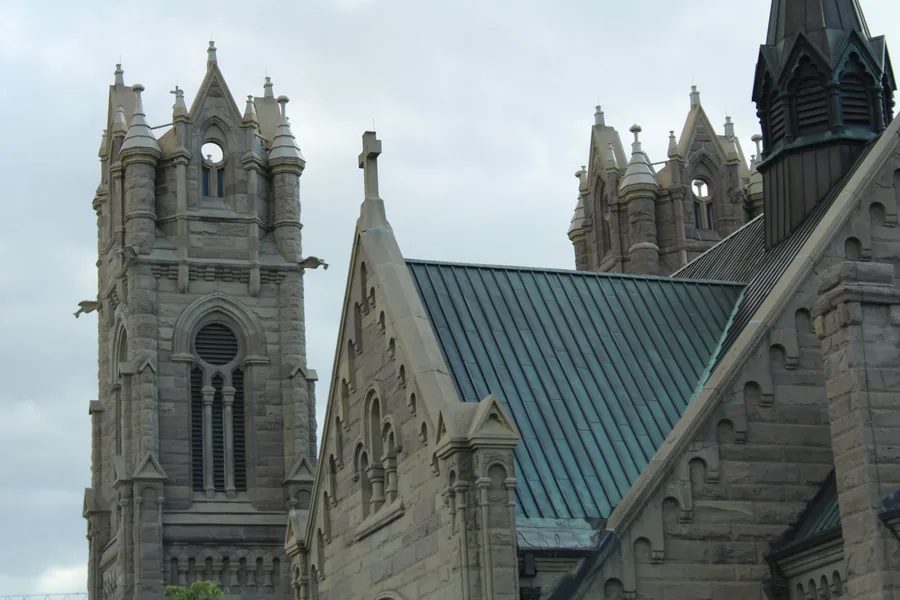 The spires and green copper roof of the Cathedral of the Madeleine seen from below.