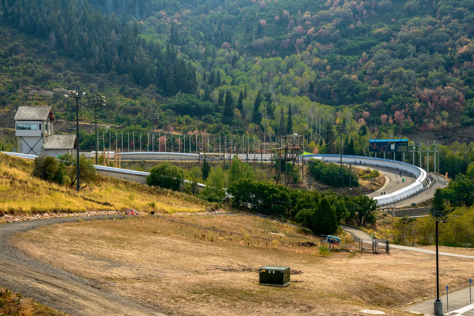 The bobsled and luge track at Utah Olympic Park curving down through the pines.