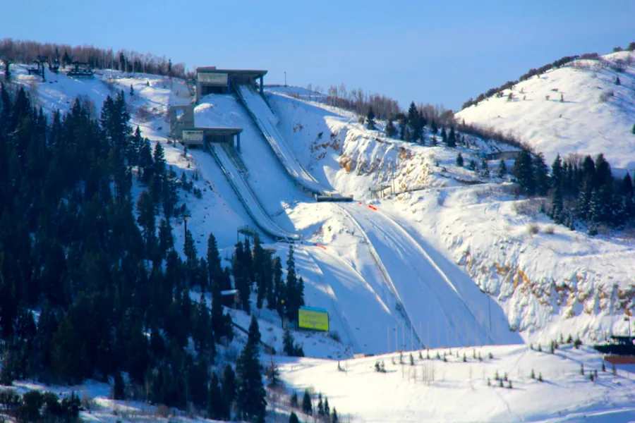 The ski jump in-runs at Utah Olympic Park under snow, the K120 and its neighbors dropping down the hillside.