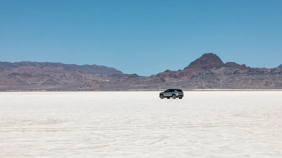 A single vehicle on the salt, the only object in a landscape with no other scale reference.